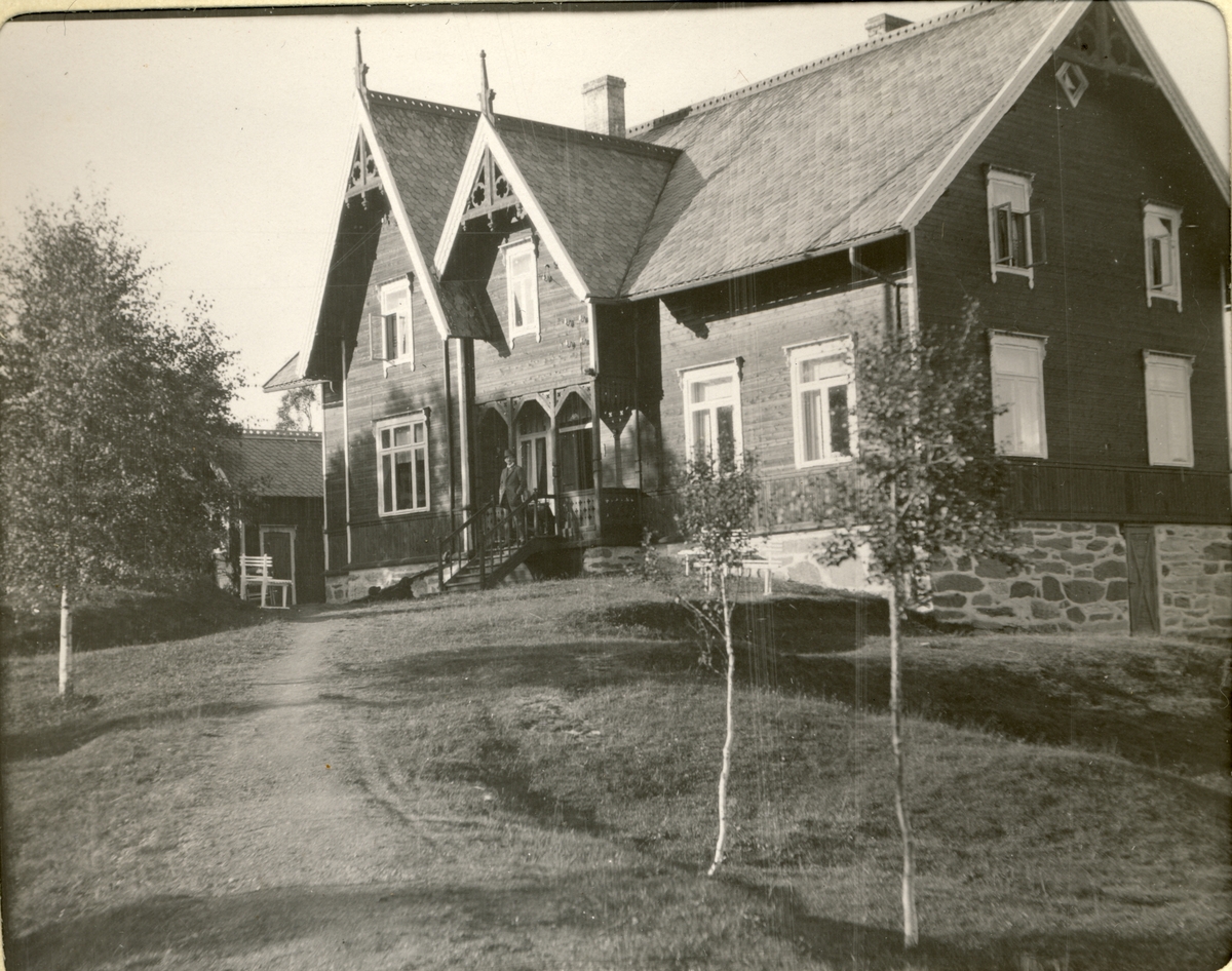 Hovedbygningen til Fearnley-familiesn Mostadmarken Verk. En mann skimtes på trappen i inngangspartiet. Fotografert 1909.