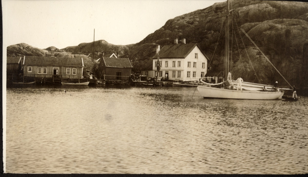 Seilbåten "Malva" har ankret opp i Ny-Hellesund på tur til Stavanger i juli 1922. Noen av deltakerne er fortsatt ombord i båten.