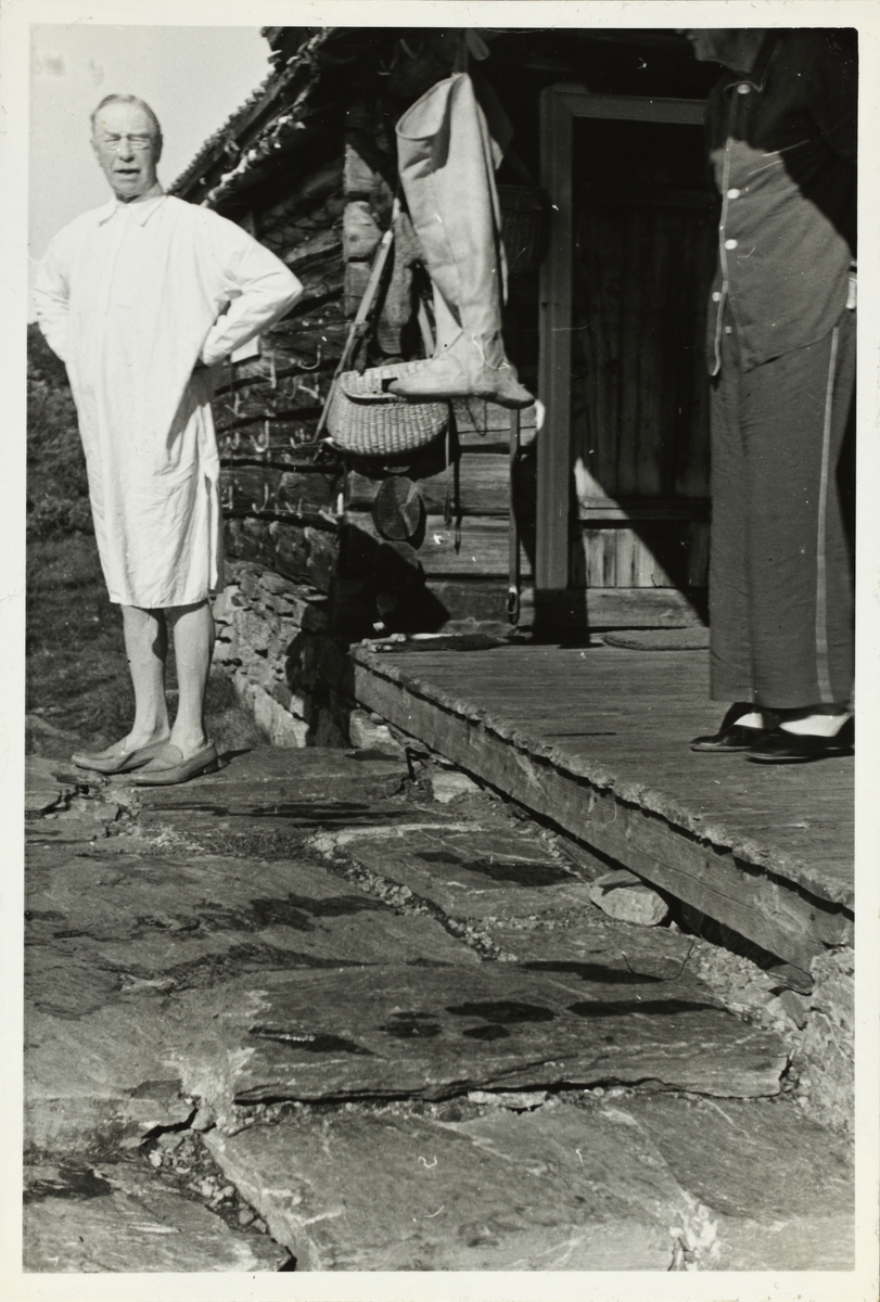 Morgen ved hytten Russboden ved Russvatnet i Jotunheimen. Westye Egeberg i nattskjorte og Thomas Fearnley i pyjamas helt til høyre. Fiskeutstyr henger fra taket. Fotografert 1952.