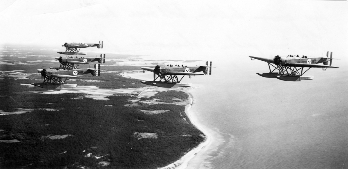 Fem flygplan S 5A Heinkel He 5 Hansa flyger över Gotland. Flygplanen är märkta med nummer 1474, 2460, 2462, 2451 och 1472. 1930-tal.