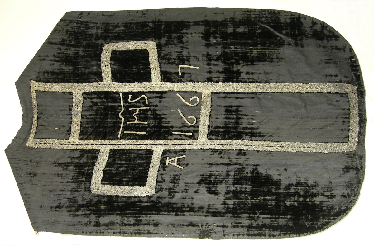 Slät sammet, svart.
Varp: svart silke
Polvarp: svart silke
Inslag: svart silke
Yllefoder i liksidig kypert (2/2), gråsvart. Tidigare foder, alternativt mellanlägg, i linne, 3-skaftad kypert (2/1), oblekt.
Mässhaken har axelsöm och en del av yttertyget mitt fram är av grövre ylle?sammet.
På framsidan 840 x 220 mm U-formad dekor av 2 spetsar i metalltråd (spunnet lan, silver) tillsammans 37 mm. Halsringning samt 110 mm djupt sprund med 15 mm bred spets i metalltråd (spunnet lan, silver).

På baksidan 1070 x 520 mm stort kors med konturer av 2 spetsar i metalltråd (spunnet lan, silver), tillsammans 30 mm breda.
IHS/A 1667 applicerat i korset med 5 mm brett tuskaftsband vävt av metalltråd (spunnet lan, silver).