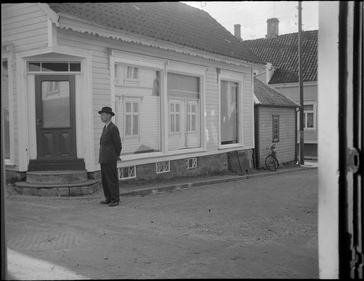 En mann med hatt foran et stengt butikklokale i Storgaten 2 i Egersund sentrum.