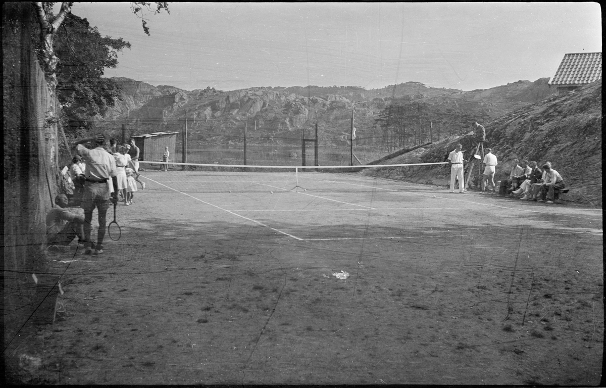 Bilder fra et privat tennisarrangement. Det er bilder fra tenniskamper, fra motstandere som hilser før/etter kampene, tilskuere, dommer og noen barn på en strand.