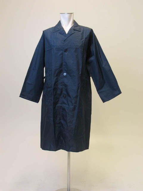 Mörkblå regnrock av vindtät textil. Knäppes med blå plastknappar. Svart textillapp vid halslinningen: "Swan Sportswear".