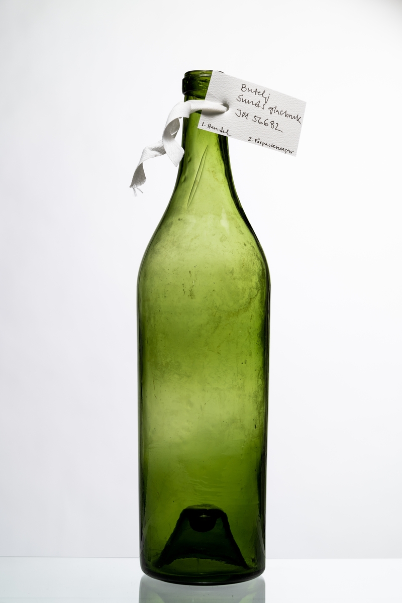 Butelj av grönt glas, avsedd för tillslutning med naturkork. Buteljen har "Kinnekullebotten" med liten kula. Hantverksmässigt tillverkad vid Sunds glasbruk, Jönköpings län. Se vidare Historik.