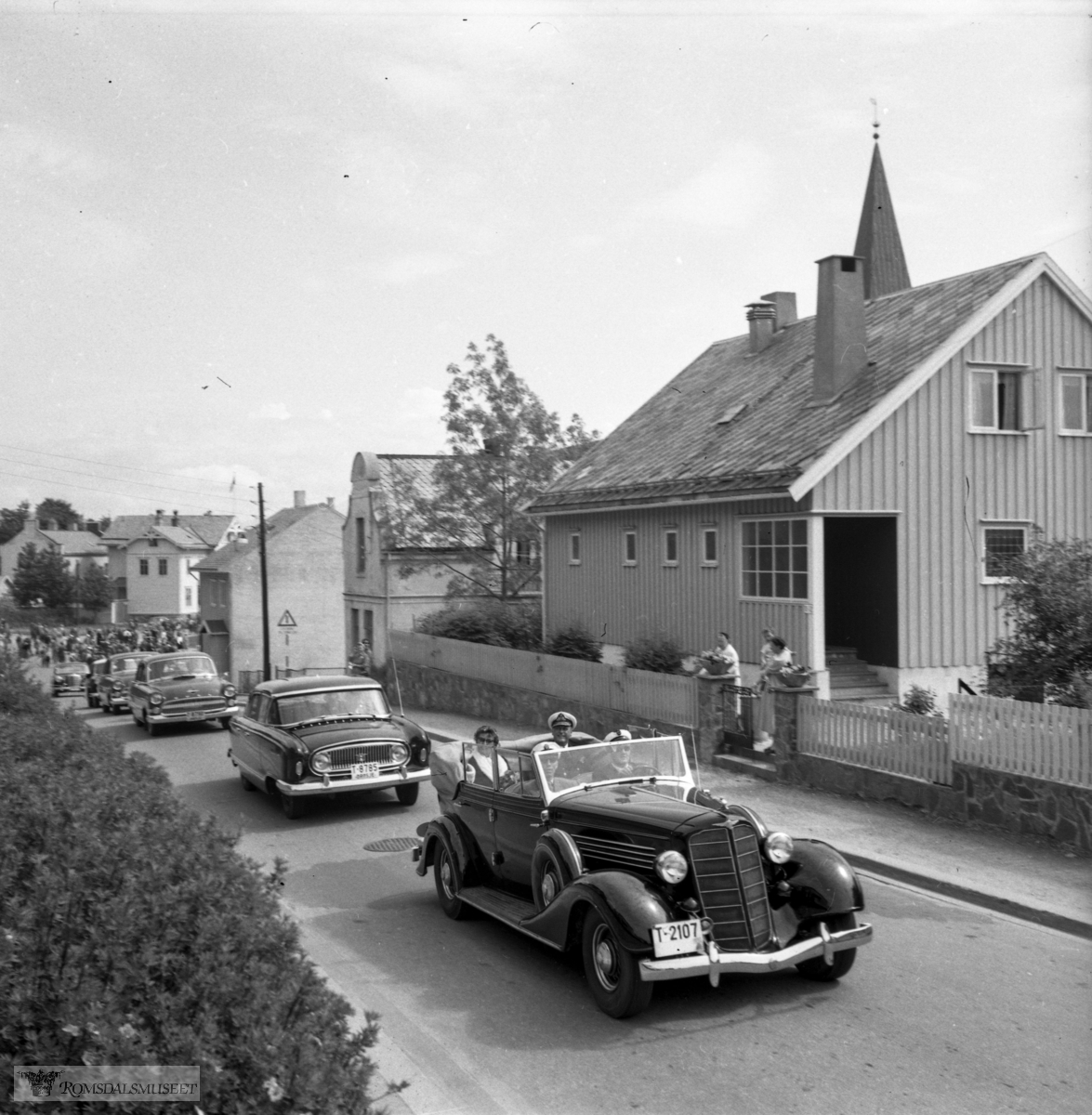 Kongebesøket 24.06.1958..T-2107 er Buick 1935, drosje T-8785 er Nash 1955. (Eske: "Kongebesøket i 1958")