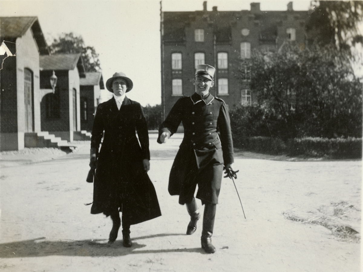 Text i fotoalbum: "Förbindelsekursen 1920". Soldat och kvinna på gården.