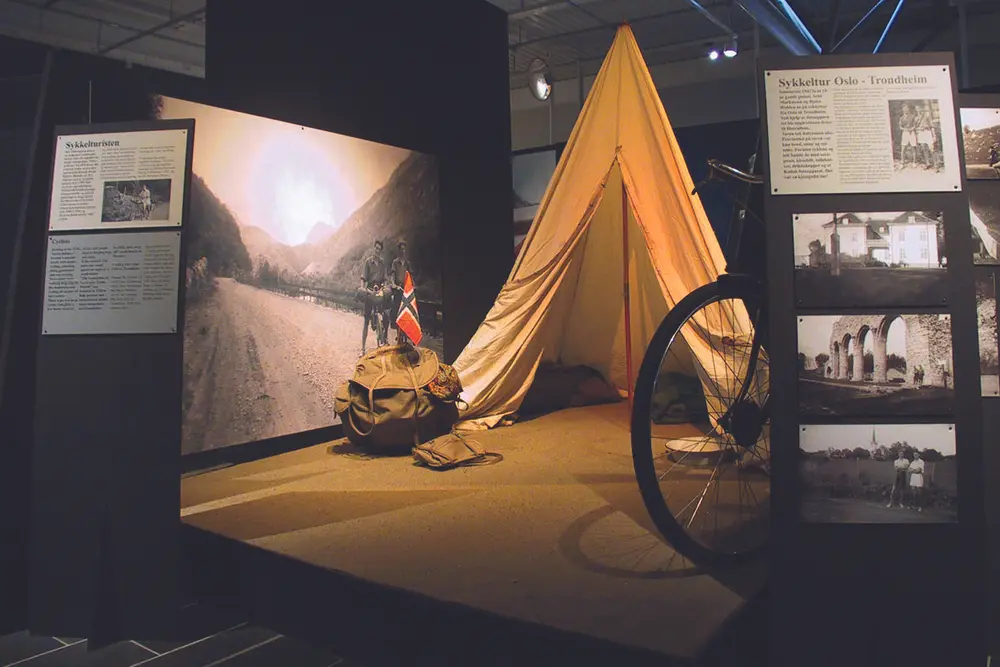 Et telt og sekk, samt noen fotografier stilt ut på Norsk vegmuseum.