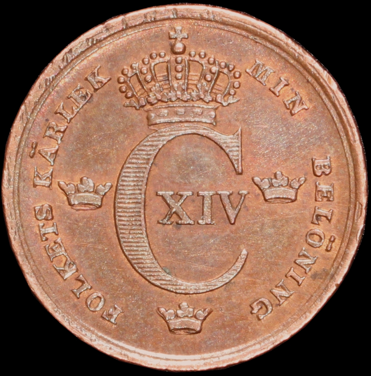 Mynt med valören 1/6 skilling banco. Åtsidan har Kung Karl XIV Johans monogram, tre kronor kungens valspråk. Frånsidan visar valören, två korslagda pilar samt en växtkrans.