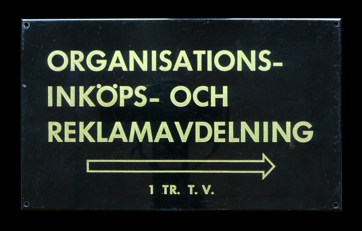 Tre skyltar från Östgötabankens kontor.

Skylt 1:  Skylt i mässing överdragen med svart emalj. På skylten står det "HISS" och under det finns en pil som pekar vänster. Text och symbol är nedsänkta. På baksidan sitter en frimärksliknande lapp med siffran 13.

Skylt 2:  Skylt i mässing överdragen med svart emalj. På skylten står det "Organisations- Inköps- och Reklamavdelning" och under det finns en pil som pekar höger. Under detta står "1 TR. T. V." Text och symbol är nedsänkta. På baksidan sitter en frimärksliknande lapp med siffran 12.

Skylt 3:  Skylt i vitmetall med svarta nedsänkta bokstäver. På skylten står det "Östergötlands Enskilda Bank Direktionen 1 tr". På baksidan sitter en frimärksliknande lapp med siffran 14.