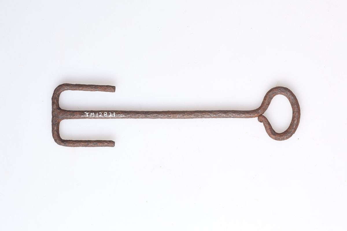 Nøkkelen har to lange mothaker i enden, som går inn i låsen. Har vært brukt til en skuvlås av tre.