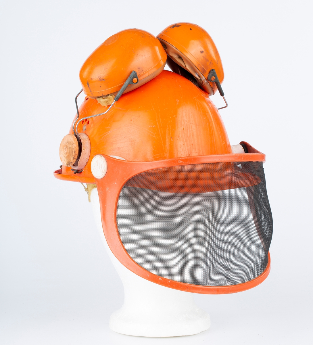 Hjelm med øreklokker og netting visir. Orange.
Brukt til skogsarbeid.