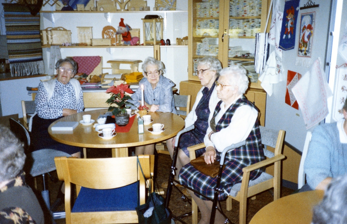 Några kvinnor sitter till bords och dricker kaffe i Brattåsgårdens hobbylokal, cirka 1990 - 1991. Från vänster: 1. Elin Jansson (1905 - 1991). 2. Okänd. 3. Rut Göransson (1905 - 1999). 4. Alida Ekström (1896 - 1994).