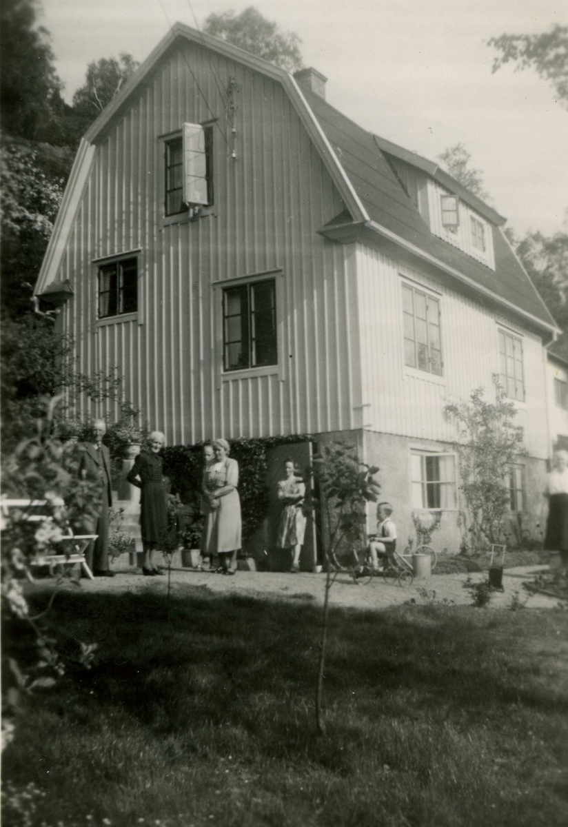 Familjen Olof Olsson står utanför bostaden "Alphyddan" Torrekulla 1:25 på Gamla Riksvägen 13, 1940-tal. Relaterat motiv: A1198.