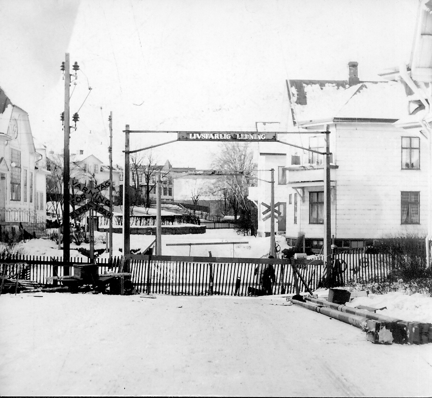 Bommarna vid järnvägskorsningen på Bäckgatan har ersatts med ett staket. Till vänster, på andra sidan spåret, syns Missionskyrkan i kv Skepparen.