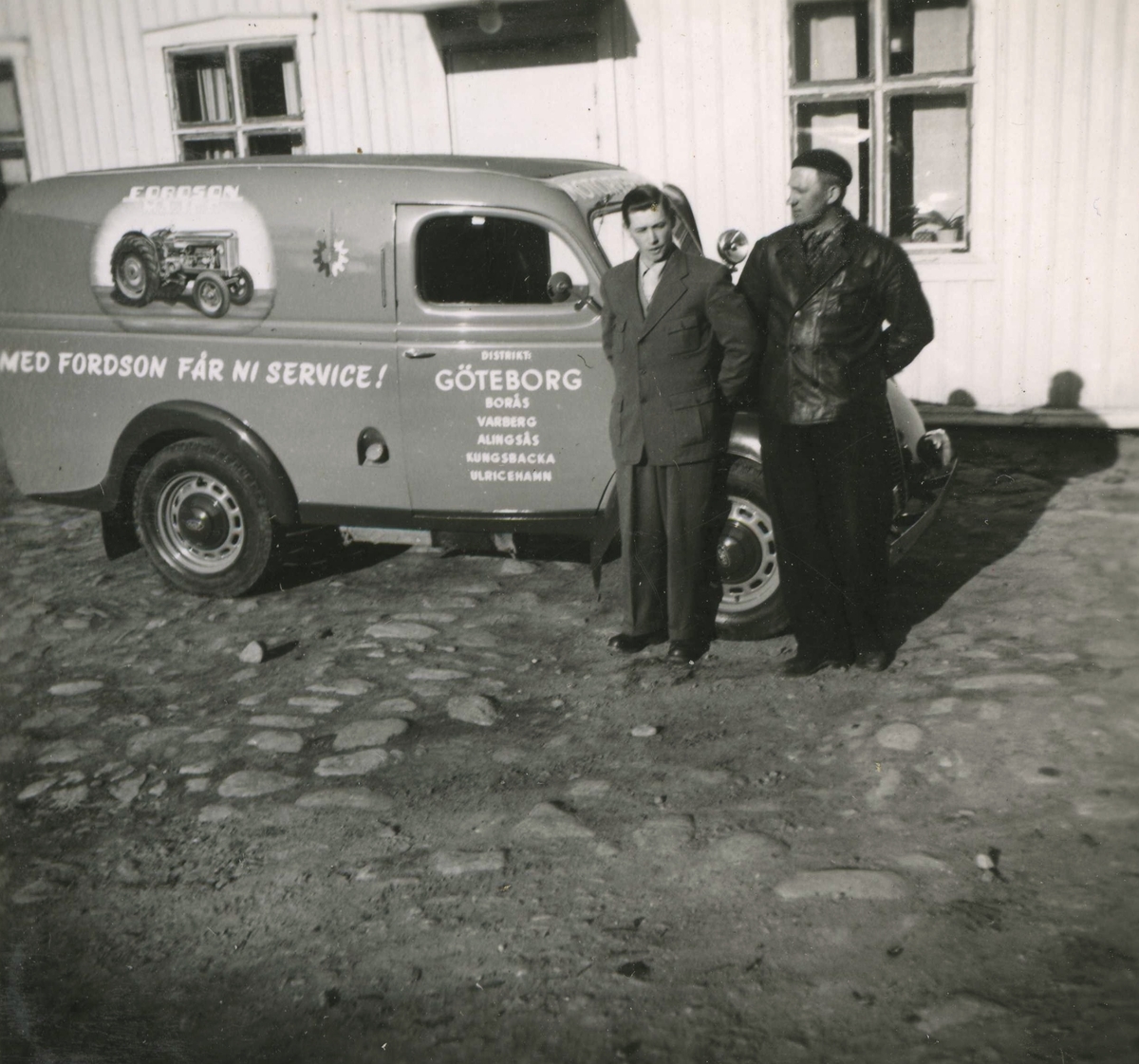 Två män står vid en bil på Ekans gårdsplan år 1953. 
Från vänster: Rolf Svensson (född i Släp 1909, avliden i Kållered 1989) samt traktorreparatör Malte. Rolf arrenderade först Ekans gård, sedan köpte han gården men sålde den vidare cirka 1965.