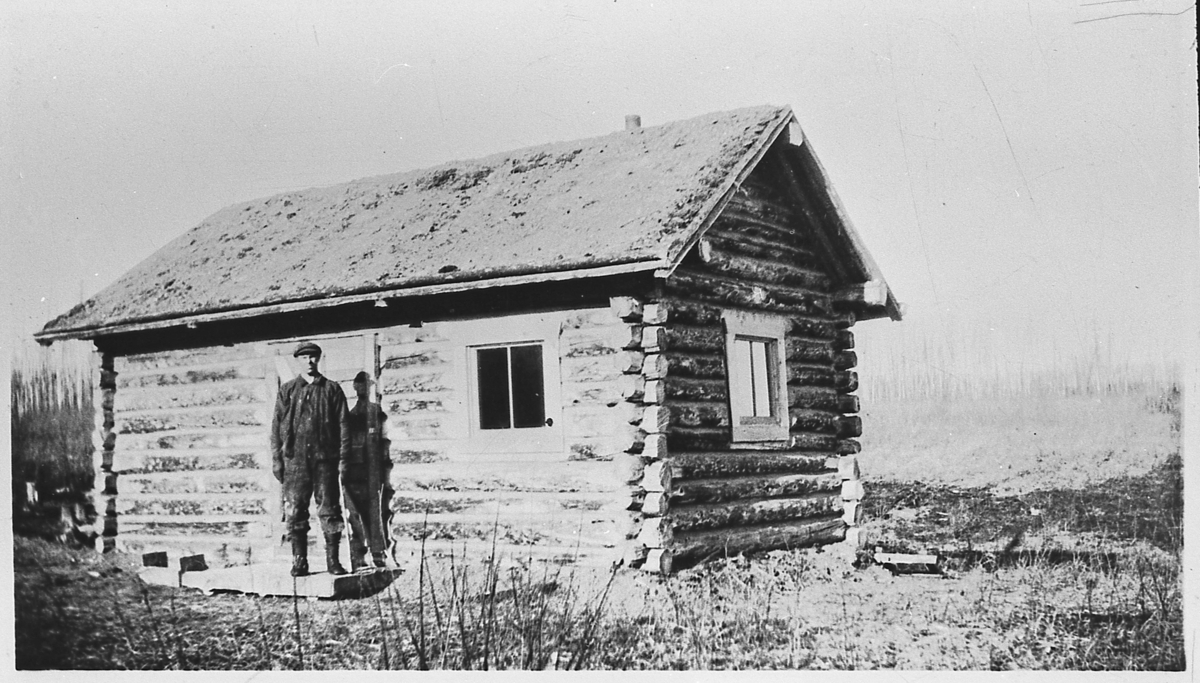 Logghuset til Kristoffer Tangen i 1931, mens han var pelsjeger i Canada. Ved huset står Halvor Grønseth.