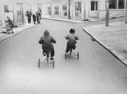 Brit og Kari Feyling på trehjulssykkel i Storgaten, 1952.