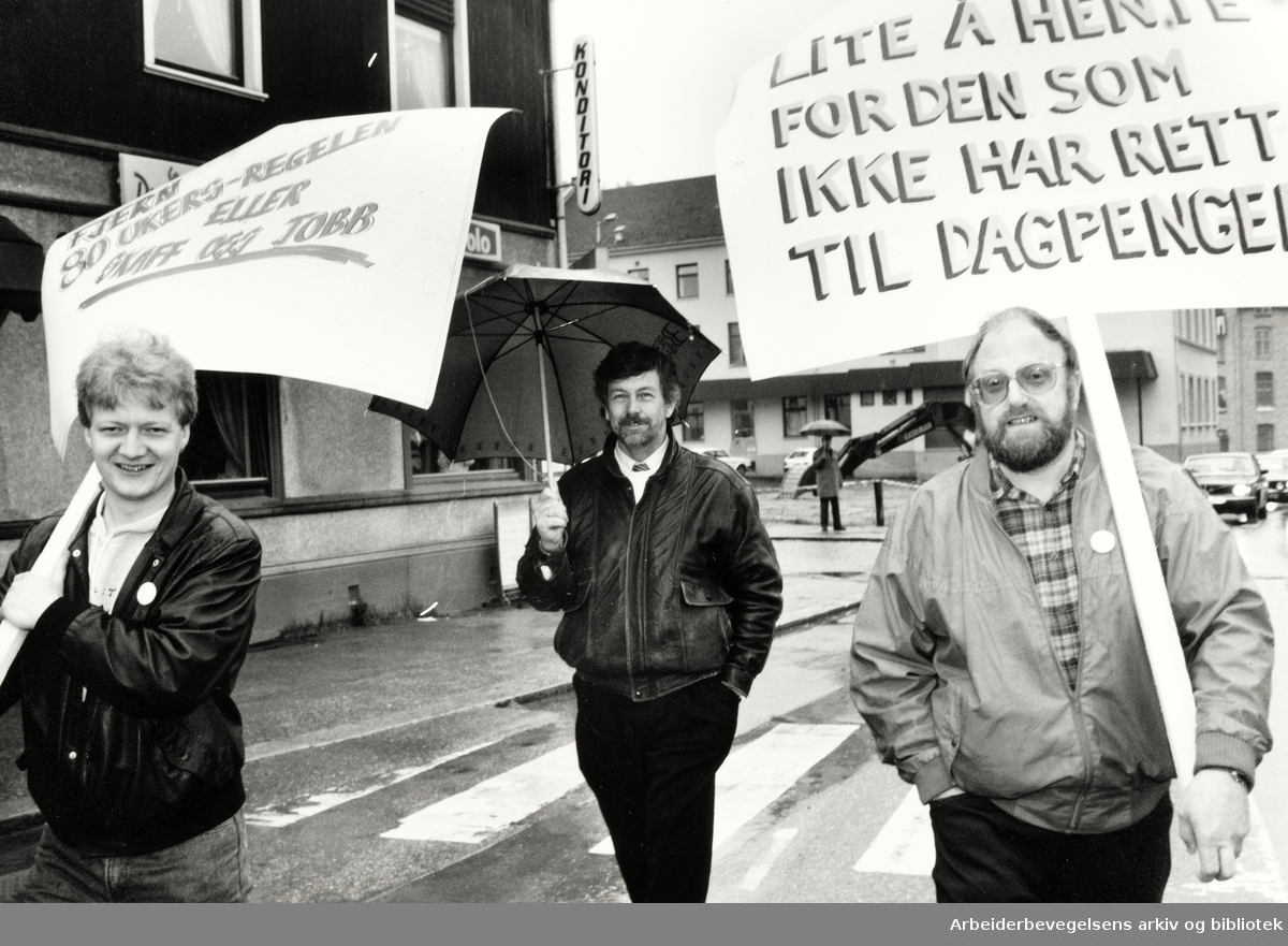 1. mai 1992, Oslo. Parole:" Fjern 8o-ukers regelen eller skaff oss jobb" og "Lite å hente for den som ikke har rett til dagpenger" Mannen i midten er John Stene.