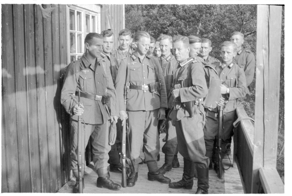 Tyske soldater på patrulje, fotografert utenfor hytte.
