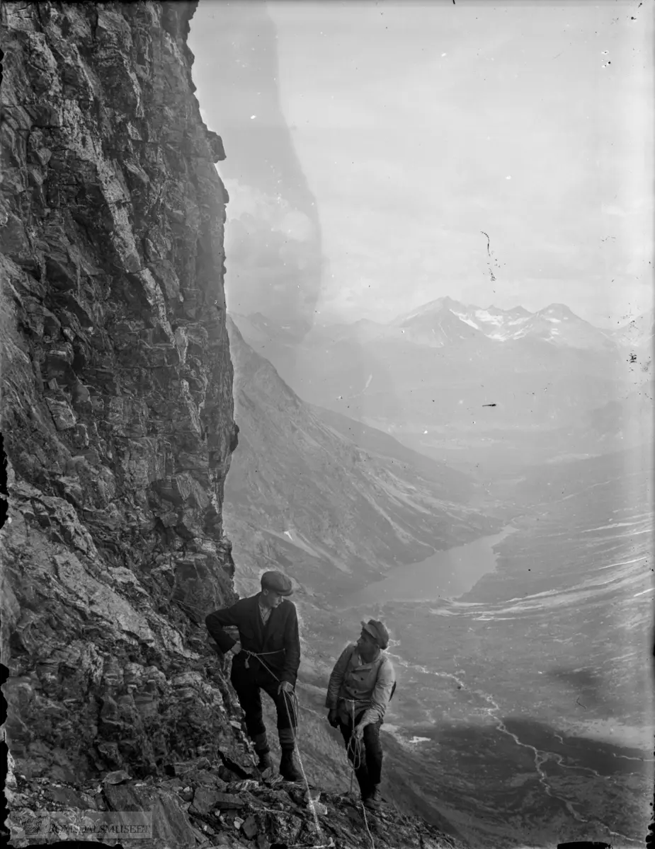 Klatring i Romsdalshorn nedanfor Halls renne. Venjesdalen med Venjesdalsvatnet. Isfjordsfjella i bakgrunnen