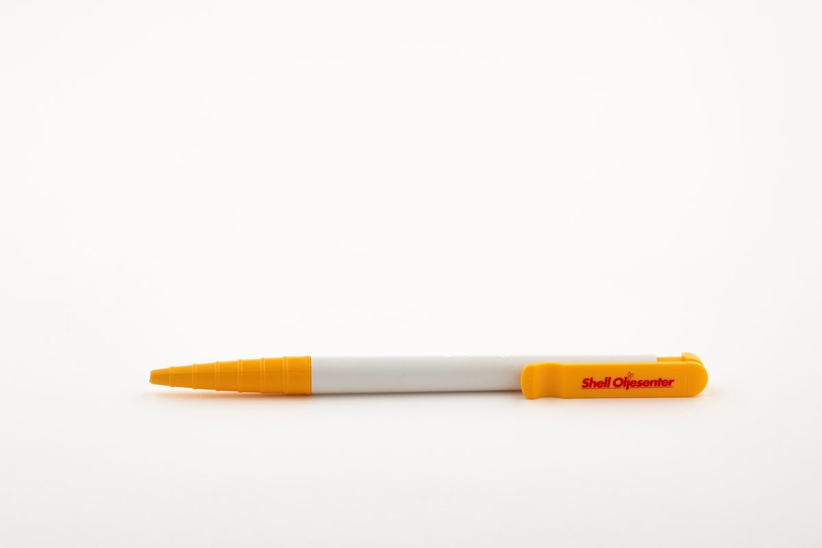 En kulepenn i gul og hvit plast. Kulepennen har en klips der det er en reklame for Shell Oljesenter.

Gjenstandene med Shell-logo er samlet inn i forbindelse med Bensinstasjonsprosjektet 2016-2019