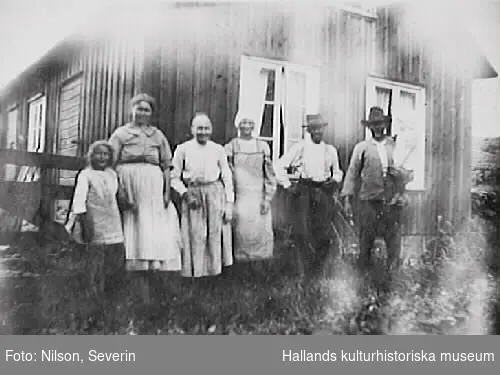Familjebild utanför ett bostadshus i Trönninge. Kan det vara grannar till Severins "Bolsestuga"?