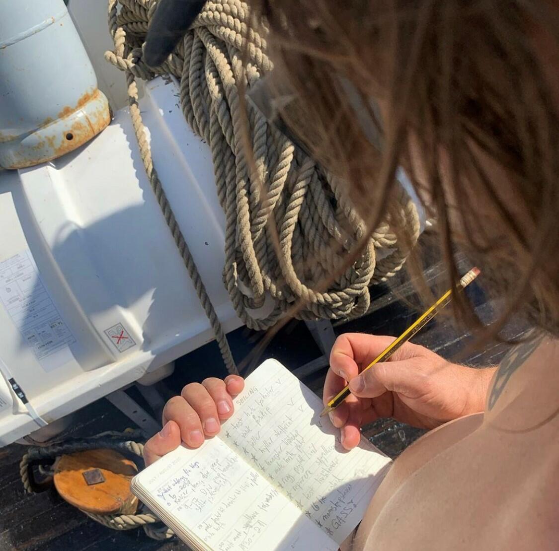mann som skriver notater i en bok