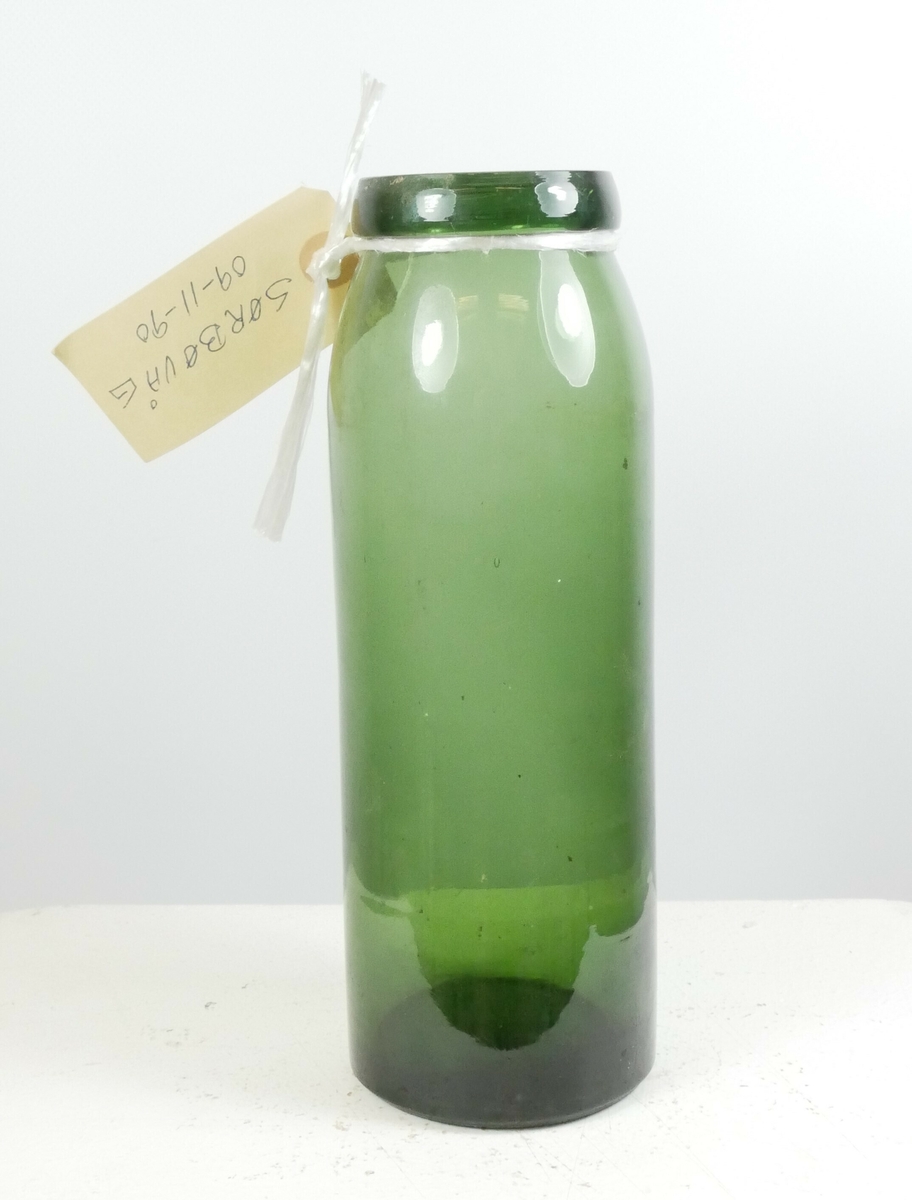 Grønn sylinderformet glassflaske.