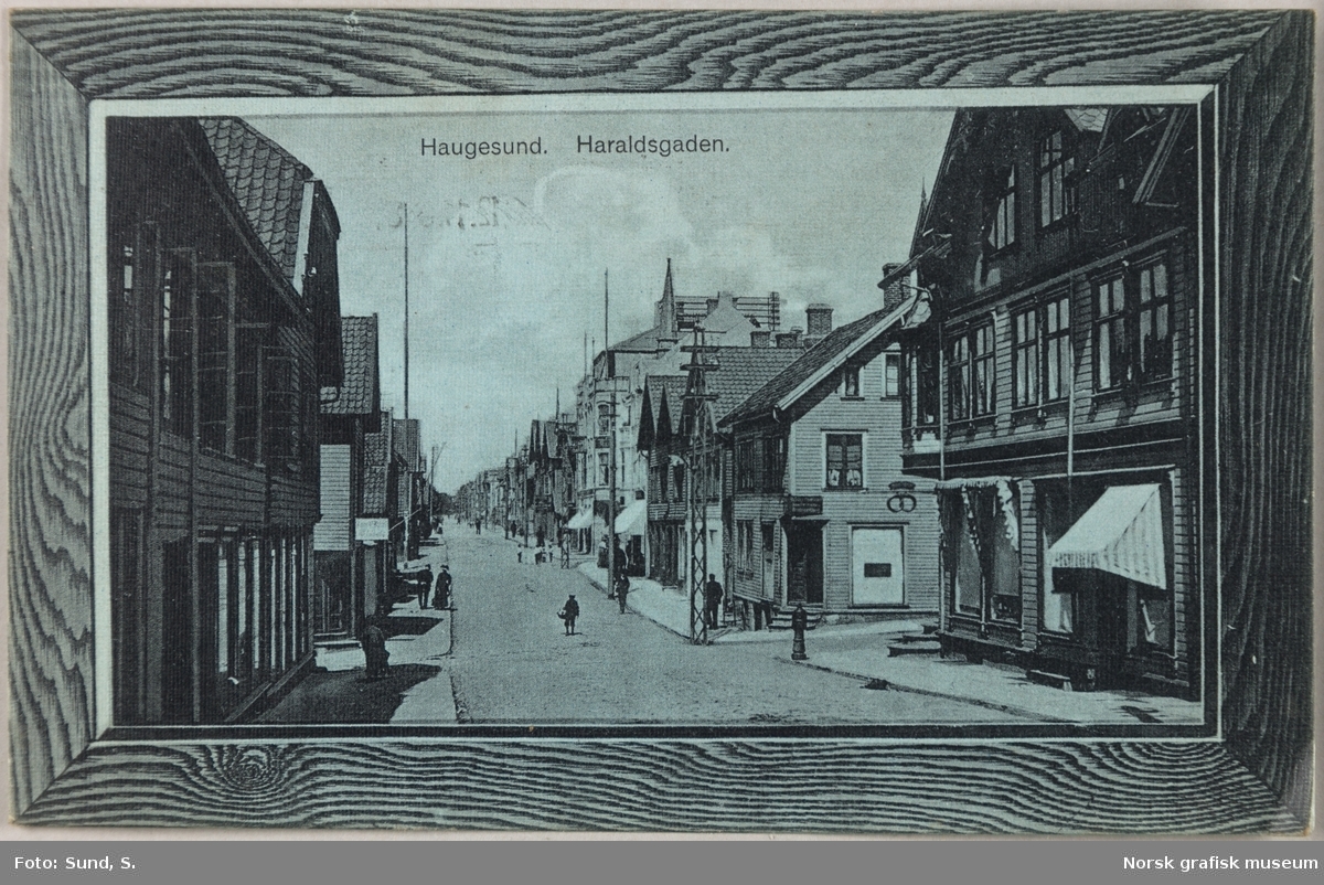 Postkort med motiv fra Haraldsgata i Haugesund. Kortet skal se ut som et bilde med treramme.