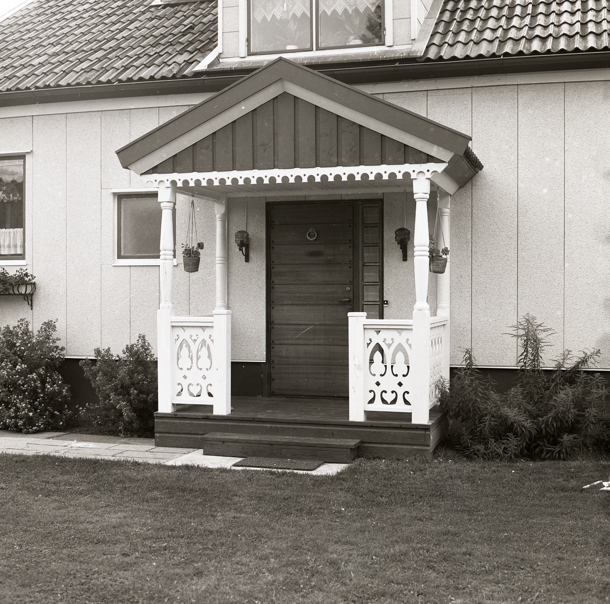 Förstukvist på en villa där fasaden ser ut att var klädd med något slags plattor, Arbrå våren 1980.