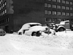 Nedsnødde parkerte biler i Oslo sentrum. Desember 1955.