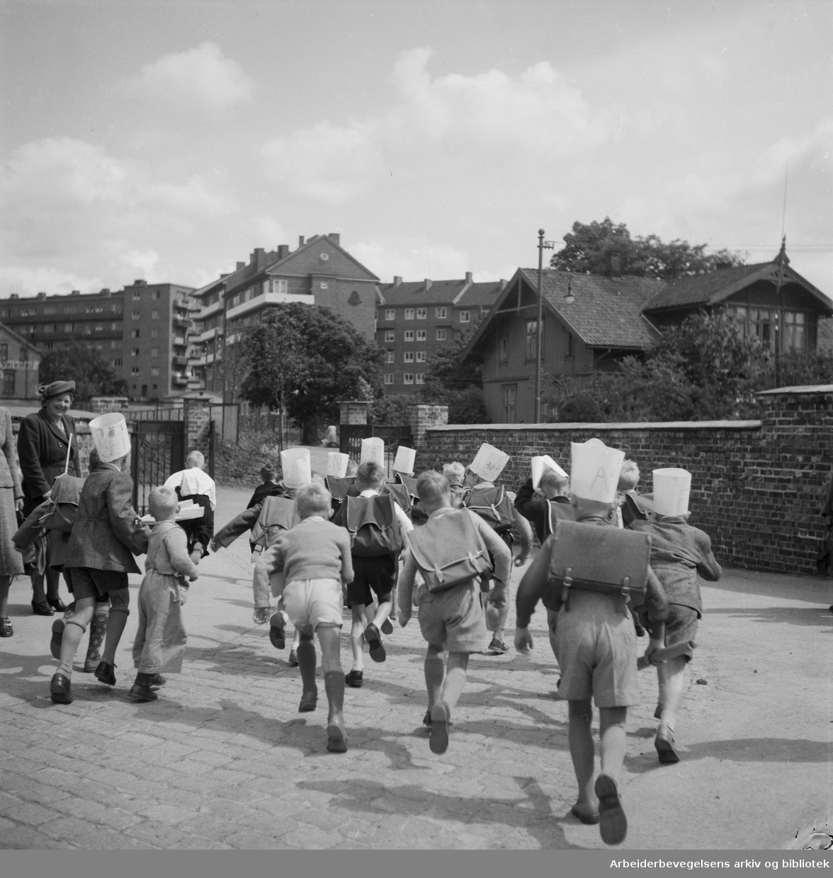 Siste skoledag før sommerferien for elevene på Rosenhof skole. Sveitservillaen til høyre i bildet ligger i Dynekilgata og ble blant annet brukt som tobakkslager for Glotts tobakksfabrikk. Nå revet. Juni 1950.