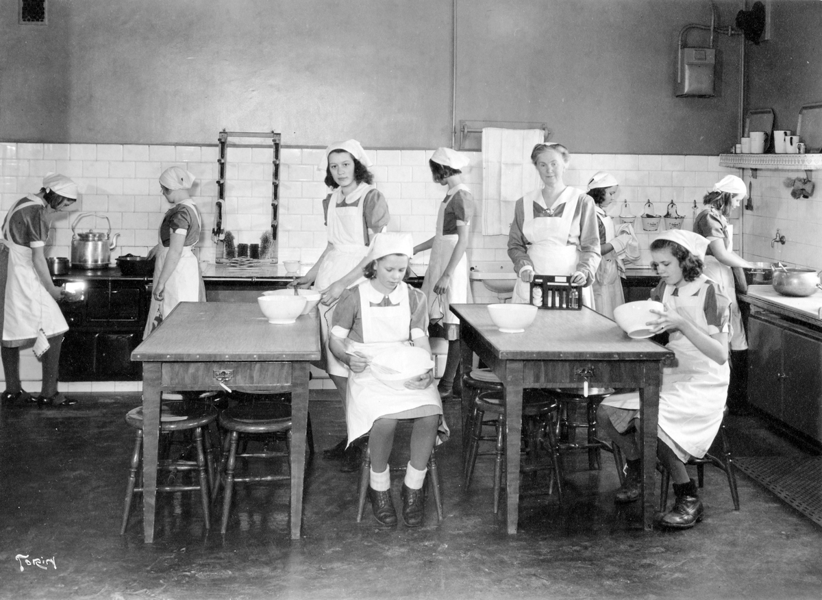 Matlagning i skolköket på Centralskolan. Skolkökslärarinnan Elsa Broman med sina elever.