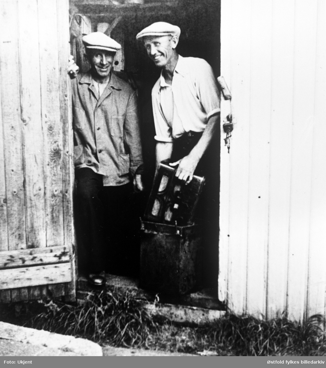 Brødrene Hans og Kr. Wergeland, Glombo  holder radioapparat som var gjemt i appelsinkasse under 2. verdenskrig.