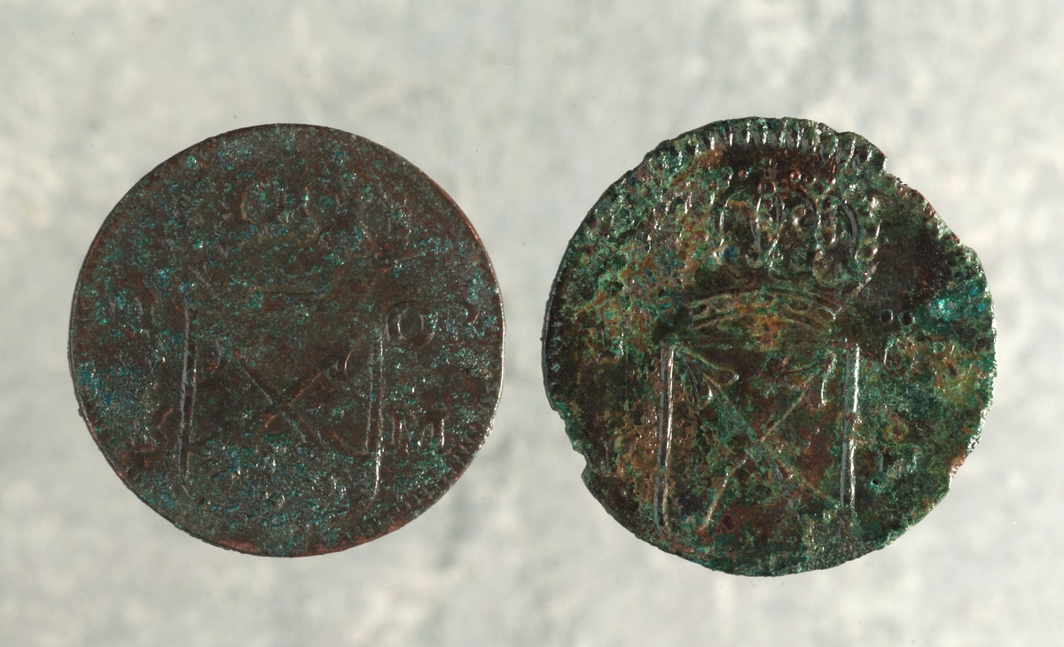 Mynt av kopparlegering. 1 öre KM. Fredrik I (1720-1751). Präglat 1724 i Stockholm. Myntet till vänster på bilden.