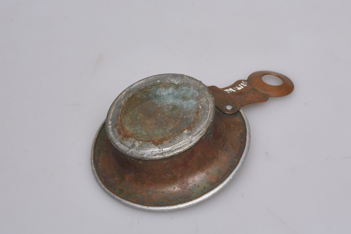 Sil som passer på toppen av et Norgesglass eller på en loddeboks. Håndtak av kobber, ring av blikk og metallduk som siler.