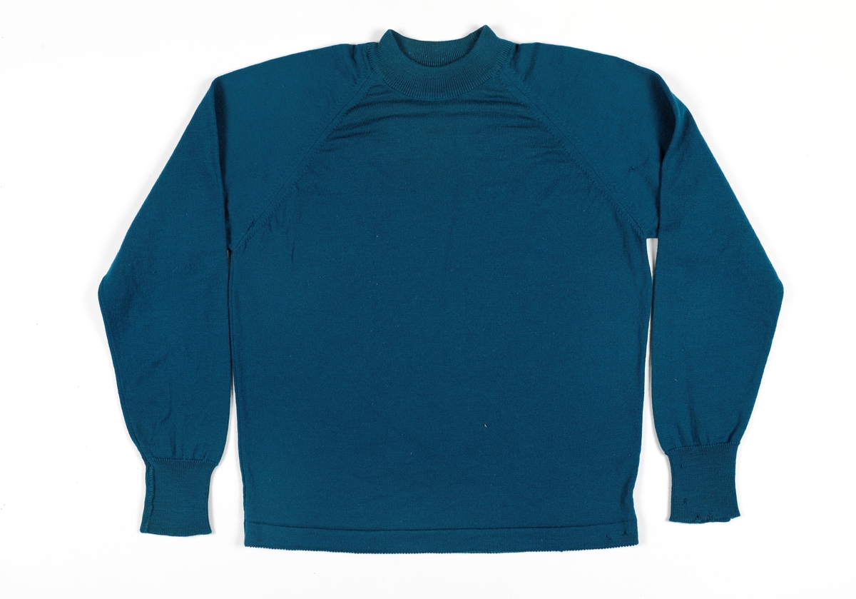 Tynn genser strikket kvalitet med rund hals. Raglanermer. Vrangbord rundt hals og på mansjetter. Flere små hull.