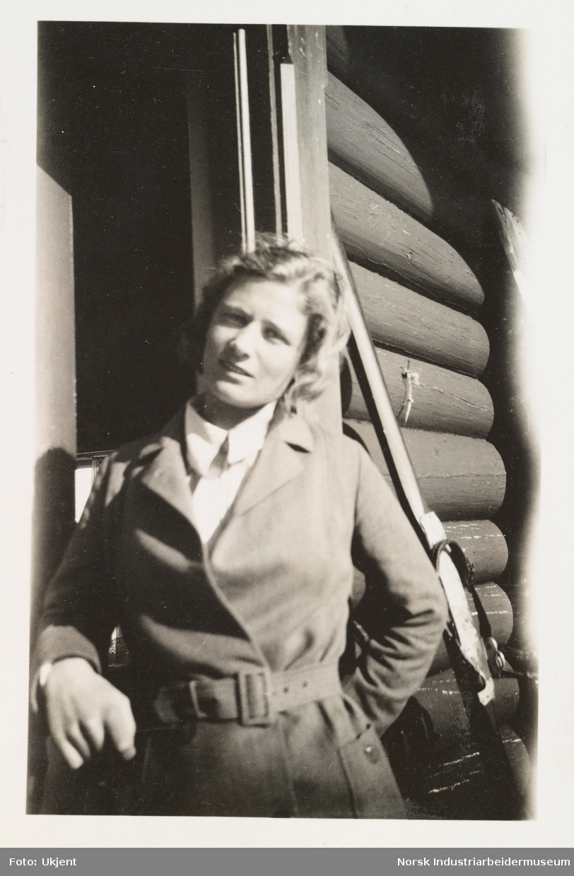 Fagerli, påsken 1931. Astrid Aubert smiler utenfor laftet hytte.