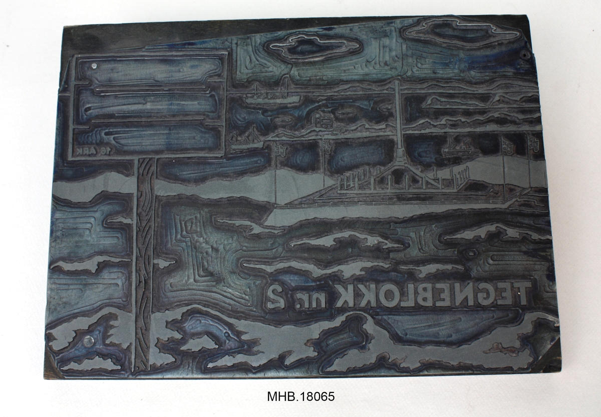 Trykkblokk laget av en kobberplate på en støtte av 5 skjøte tresorter.
Kobberplate viser et motiv av Haraldshaugen-landskapet (riksmonumentet av Harald Hårfagre), et landskap av havet og inskripsjonen: "Tegneblokk nr. 2".