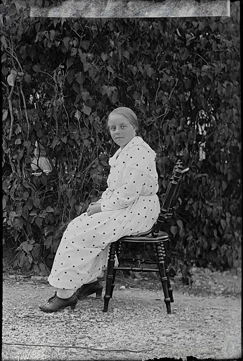 Fotografering beställd av Emma Björklund. Föreställer sannolikt pigan Emma Fredrika Björklund, född 1895-06-11 i Hubbo, död 1959-03-17 i Västerås. Hon stod skriven på Ekeholm i Barkaröby 1918-1919.