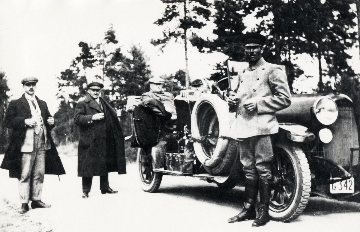 Personbil Horch, ca 1920. Tre okända män står bredvid bilen, inklusive en chaufför i uniform. I bilen sitter en fjärde man.