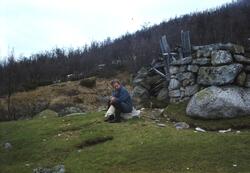Sigrid Vågen sitter å stein ved rast stein hytte nord for Ar