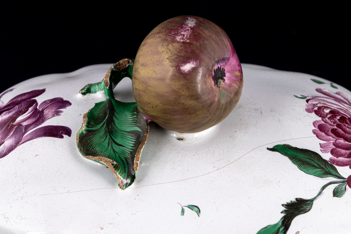 Lock till terrin, fajans, som handtag på locket en kvist med ett stort äpple. Dekor polykrom. 1700-talet.
