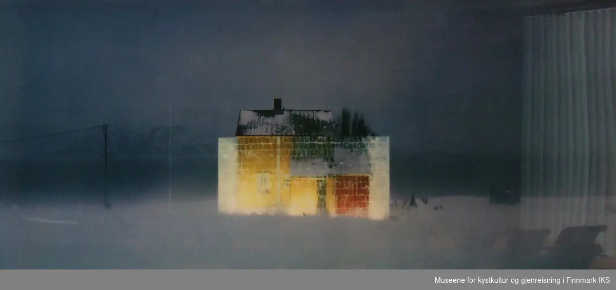 Huset bak ev vegg av is på Hanselv i mørket og i storm.