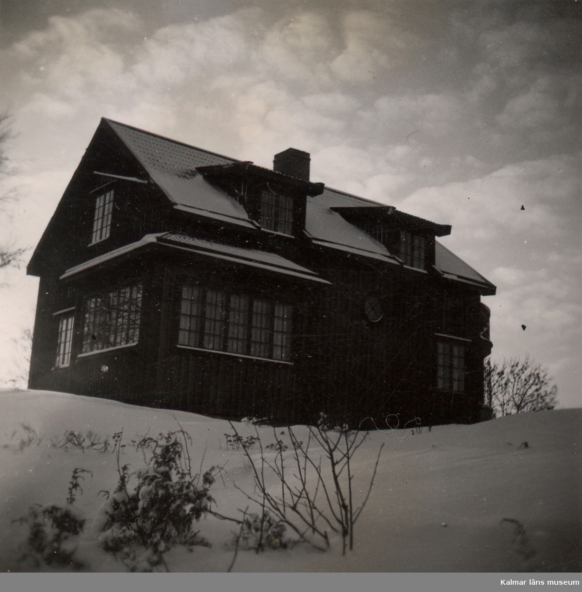 Fotografi av ett tvåvåningshus som står på en kulle. [Huset på Tjockö.]