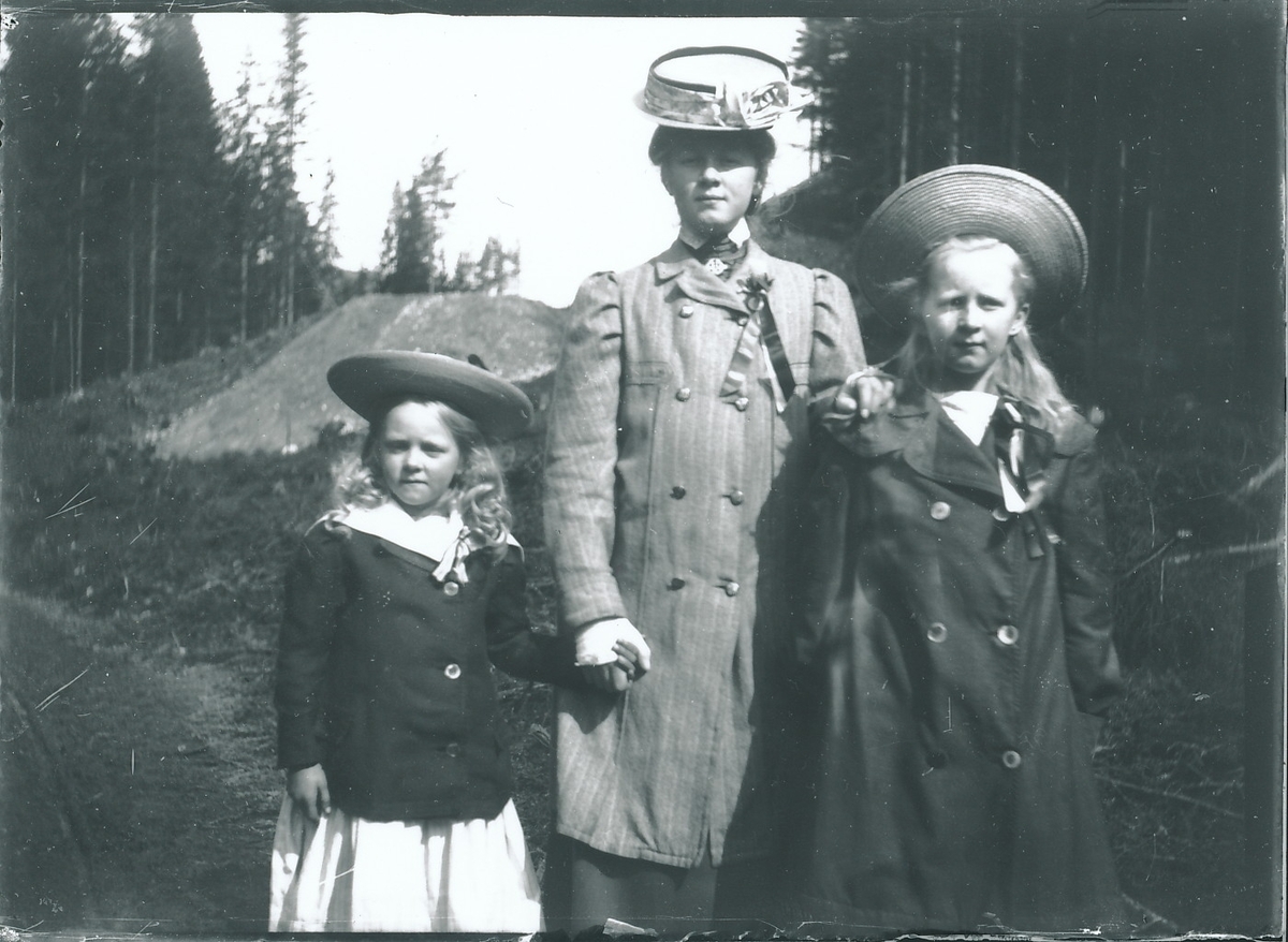 De tre eldste søstrene Rydgren i penklær og med 17.maisløyfer. Fra venstre er Eivor, Signe og Wilfried. I bakgrunnen sandbakke og granskog.