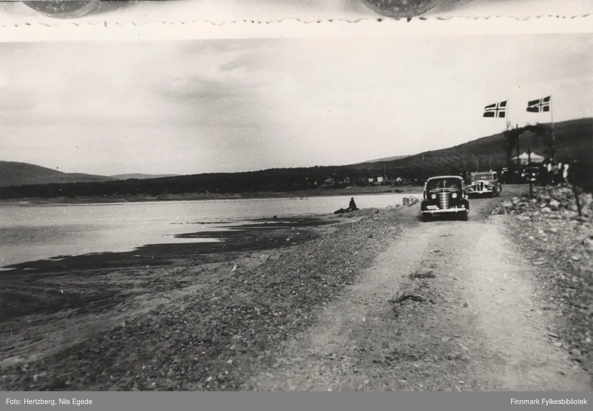 Åpningen av bukkebruen over Tanaelva i Seida, 1939. Fylkesmann Gabrielsen kjører med bil over bukkebrua. Det kommer to biler til bak ham.