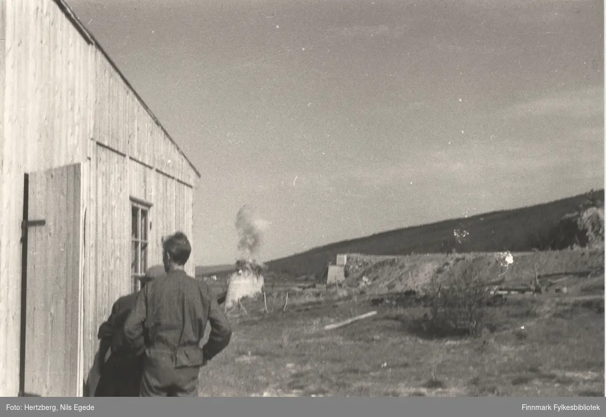 Noen menn arbeider med å bygge ny bru over Tanaelva. 1946. Toppen av østre pillar sprenges bort. Tana bru ble sprengt av tyskerne i begynnelsen av november i 1944. Se også bildene 259-263.