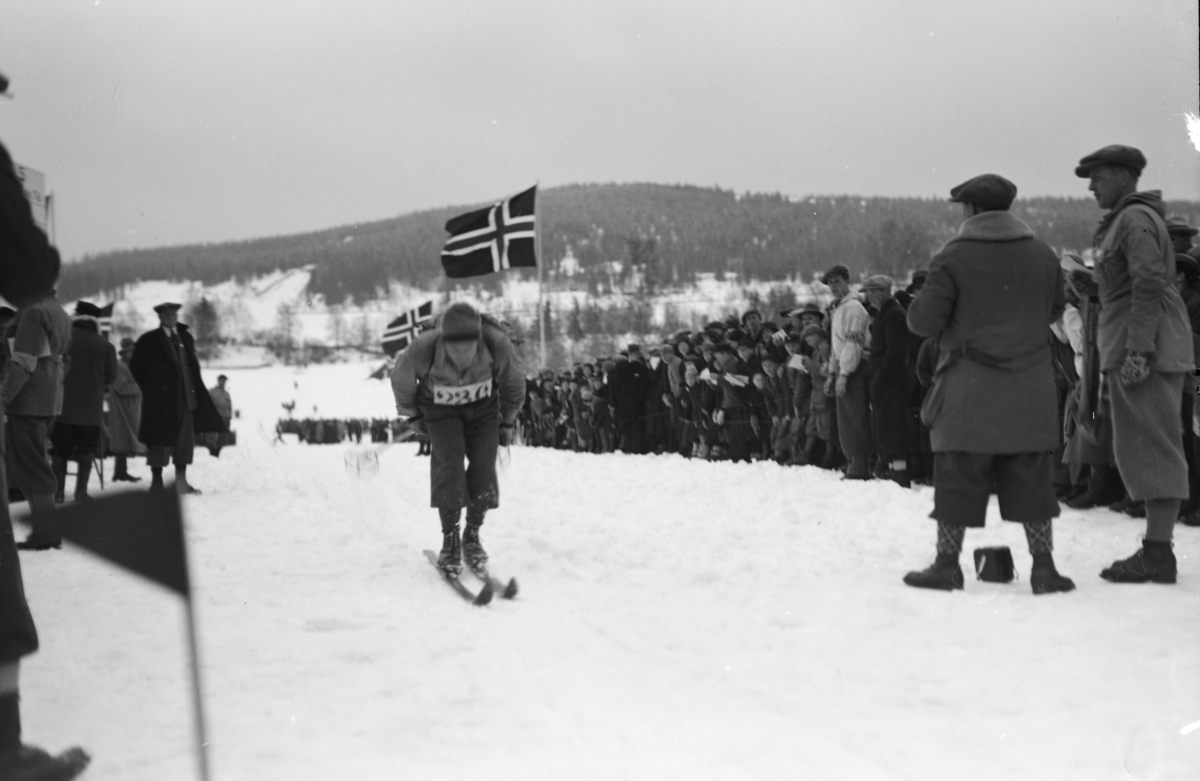 Birkebeinerrennet, start nummer 286 på vei mot mål på Lysgårdsjordet i Lillehammer, arrangører og tilskuere følger med. Lysgårdsbakken i bakgrunnen.